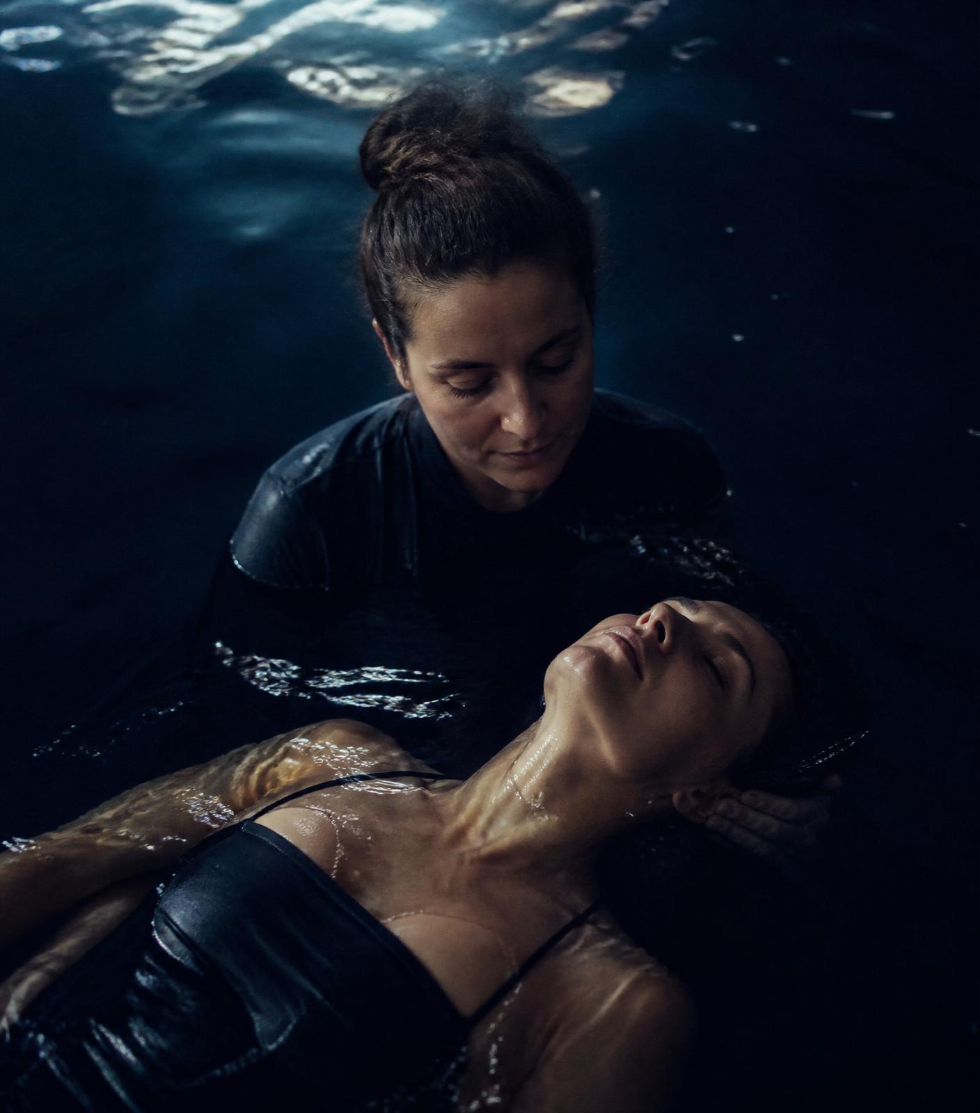 A body held in dark water, receiving